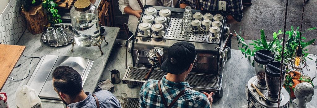 baristi koji pripremaju kavu u aparatu za espresso